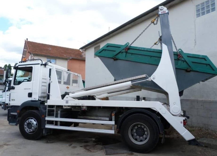 Camion déposant une benne sur un chantier